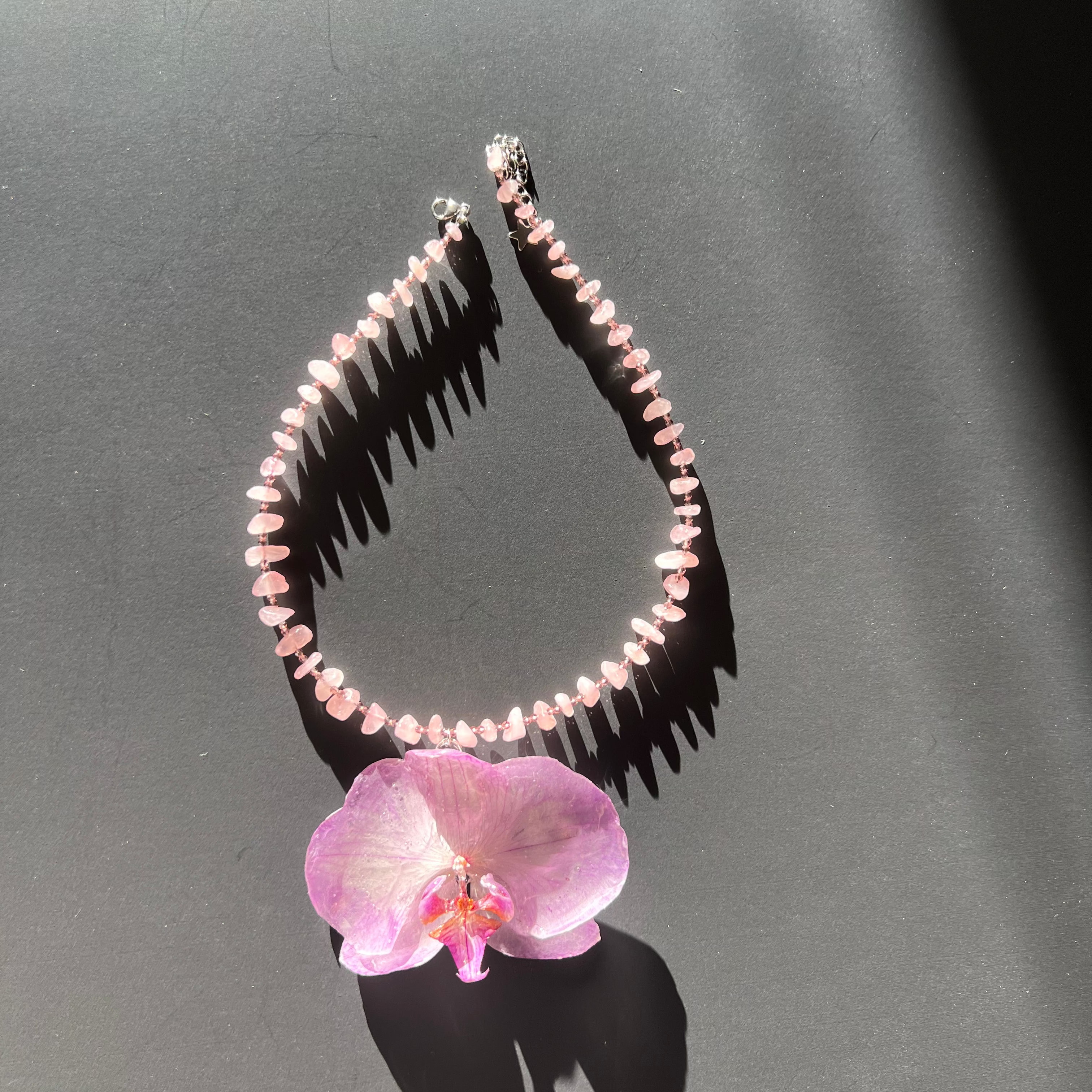 Handmade Necklace with pink beads and a natural light purple orchid flower as pendant.