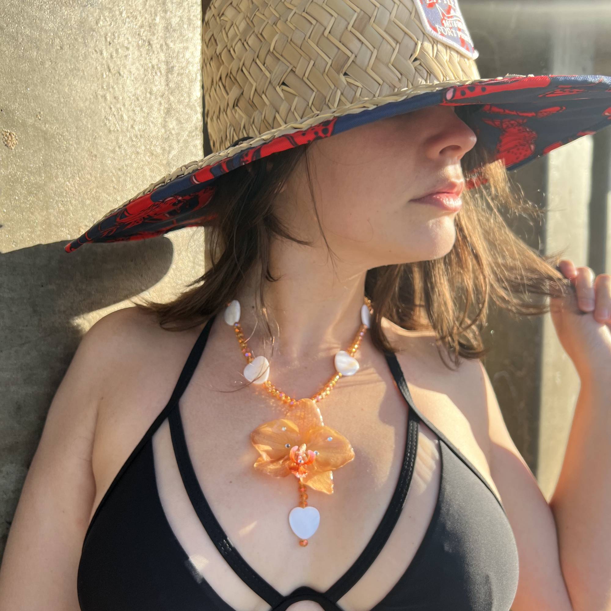 Real orange orchid flower necklace, handmade with resin-preserved tropical bloom. Features natural heart seashells and glass beads. Unique floral pendant jewelry, beach-inspired gift for her, botanical statement necklace, eco-friendly nature accessory, boho summer jewelry, one-of-a-kind artisan gift.