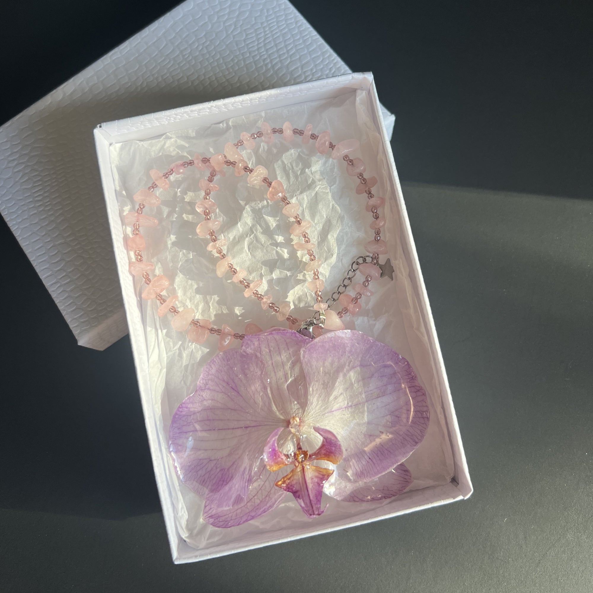 Handmade Necklace with pink beads and a natural light purple orchid flower as pendant.